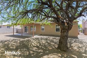 Tucson house for rent - A tree stands in front of a building with the words "FirstKey Homes" on the bottom left.