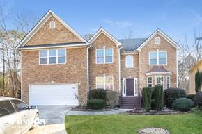 Snellville house for rent - a large brick house with a white garage door