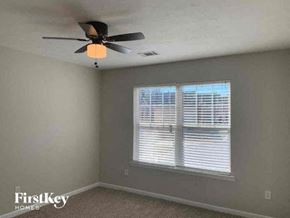 Snellville house for rent - a bedroom with a ceiling fan and a window