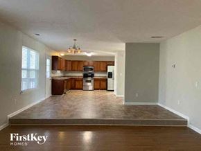 Snellville house for rent - an empty living room and kitchen with wood floors