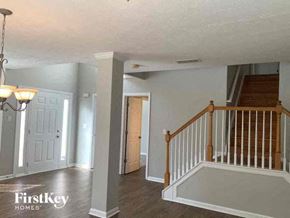 Snellville house for rent - a living room with a staircase and a white door