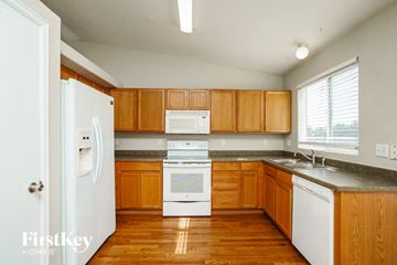 Fountain house for rent - a kitchen with wooden cabinets and white appliances