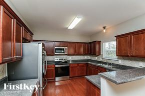 Hiram house for rent - A kitchen with wooden cabinets and a granite countertop.