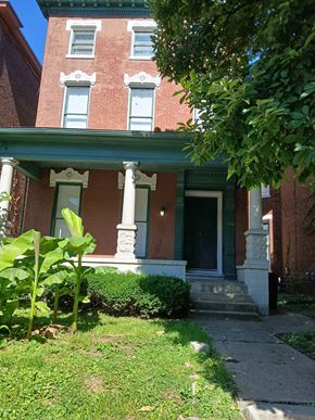 Louisville apartment for rent - the front of a brick house with a green porch