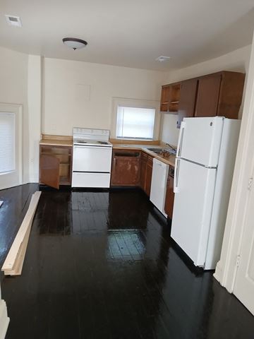 Louisville apartment for rent - an empty kitchen with white appliances and wooden floors