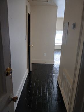 Louisville apartment for rent - a hallway with wood floors and white walls and an open door