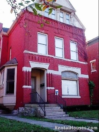 Louisville apartment for rent - A red brick house with a black iron railing on the steps.