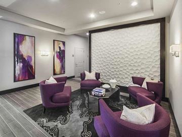 Harrison apartment for rent - A living room with purple chairs and a black coffee table.