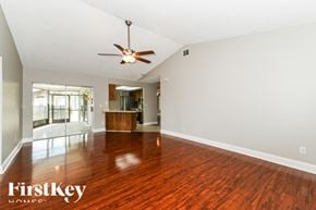 Fort Myers house for rent - A spacious room with a wooden floor and a ceiling fan.