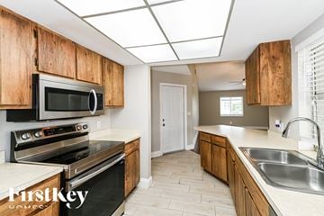 Fort Myers house for rent - A kitchen with wooden cabinets and stainless steel appliances.