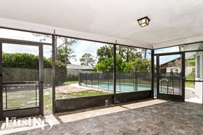 Fort Myers house for rent - A patio with a pool and a black gate.