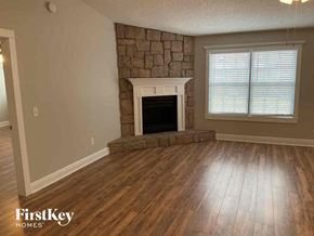 Fleming Island house for rent - a living room with a stone fireplace and wooden floors