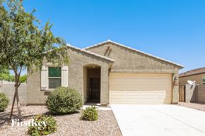 San Tan Valley house for rent - a tan brick house with a garage door and a tree