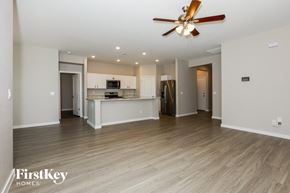 San Tan Valley house for rent - an empty living room and kitchen with a ceiling fan