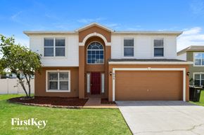 Davenport house for rent - A two-story house with a red door and a brown garage door.