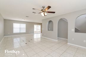 Davenport house for rent - A spacious room with a ceiling fan and arched windows.
