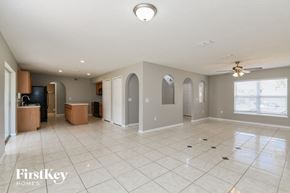 Davenport house for rent - A spacious empty room with a ceiling fan and a large window.