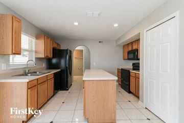 Davenport house for rent - A kitchen with wooden cabinets and black appliances.