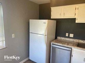 Cincinnati house for rent - a kitchen with a white refrigerator and white cabinets