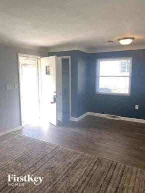 Cincinnati house for rent - an empty living room with blue walls and a door