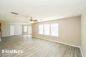 Jacksonville house for rent - A spacious room with wooden flooring and a ceiling fan.