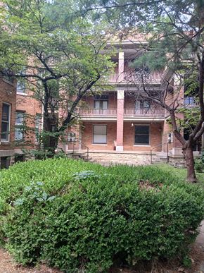 Louisville apartment for rent - a brick building with trees and bushes in front of it