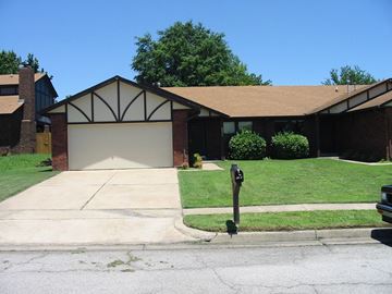 Tulsa house for rent - A house with a garage and a driveway.