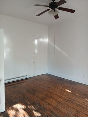 Louisville apartment for rent - an empty room with a ceiling fan and wood floors
