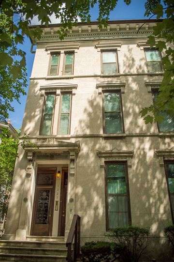 Louisville apartment for rent - a building with green windows and a tree in front of it