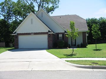 Broken Arrow house for rent - a house with a white garage door and a lawn