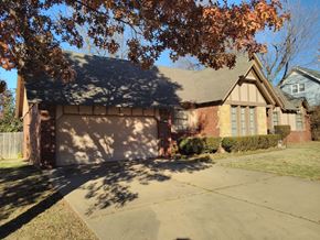 Tulsa house for rent - a house with a driveway and a garage door