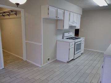Tulsa house for rent - A white kitchen with a stove top oven and white cabinets.