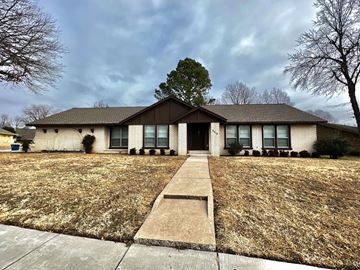 Tulsa house for rent - front view of a white brick house with a lawn and a sidewalk