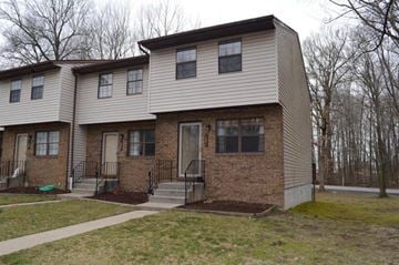 Michigan City townhouse for rent - A two-story house with a front porch and a small front yard.