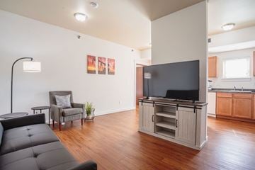 Watford City apartment for rent - A living room with a grey couch and a television.