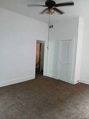 Louisville apartment for rent - A room with a ceiling fan and carpeted floor.