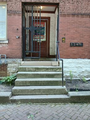 Louisville apartment for rent - A brick building with a door and steps leading up to it.