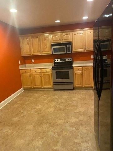 Rome apartment for rent - A kitchen with a black refrigerator, wooden cabinets, and a black stove top oven.