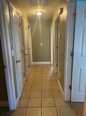 Rome apartment for rent - A hallway with white doors and tiled floors.