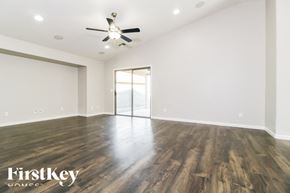 Buckeye house for rent - A spacious room with wooden floors and a ceiling fan.