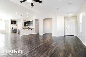 Buckeye house for rent - A spacious room with wooden floors and a ceiling fan.