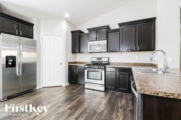 Buckeye house for rent - A kitchen with black cabinets and a stainless steel refrigerator.