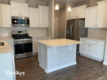 Denver house for rent - a kitchen with white cabinets and a white counter top