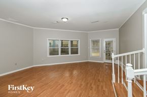 Memphis house for rent - A room with wooden floors and white railings.