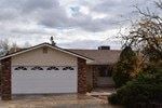Clarkdale house for rent - A house with a white garage door and a brick chimney.