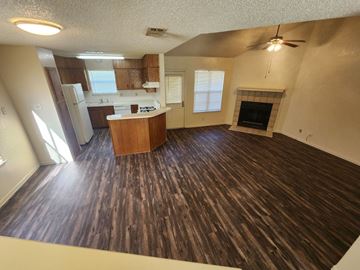 Killeen apartment for rent - A living room with a fireplace and a kitchen area in the background.