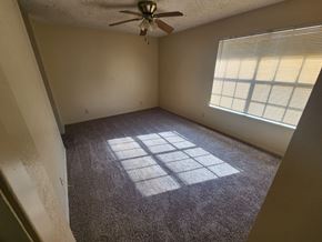 Killeen apartment for rent - A room with a ceiling fan and a window with blinds.