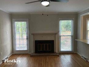 Charlotte house for rent - an empty living room with a fireplace and wood floors