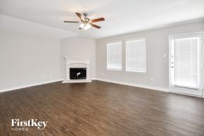 Lavon house for rent - A spacious room with a fireplace and a ceiling fan.