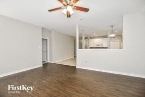 Lavon house for rent - A spacious room with a ceiling fan and wooden flooring.